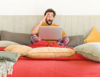 Genç sakallı adam mutlu, şaşkın ve şaşırmış görünüyor, gülümsüyor ve inanılmaz ve inanılmaz iyi haberleri fark ediyor.