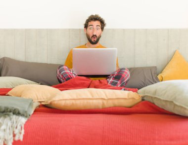 Genç sakallı adam şok olmuş ve ağzı açık, kendini işaret ederek şaşırmış görünüyor.