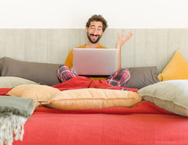 Genç sakallı adam mutlu, şaşırmış ve neşeli hissediyor, olumlu bir tavırla gülümsüyor, bir çözüm ya da fikri fark ediyor.