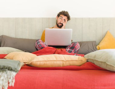 Genç sakallı adam yorgun, sıkıcı ve sıkıcı bir işin ardından sıkılmış, hayal kırıklığına uğramış ve uykulu hissediyor.