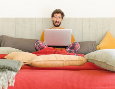 Genç sakallı adam tiksinmiş ve rahatsız olmuş hissediyor. Dilini dışarı çıkarıyor. İğrenç ve iğrenç bir şeyden hoşlanmıyor.