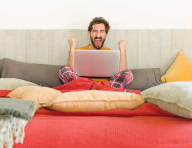 Genç sakallı adam sinirli bir ifadeyle ya da yumruklarıyla başarıyı kutlarken agresif bir şekilde bağırıyor.