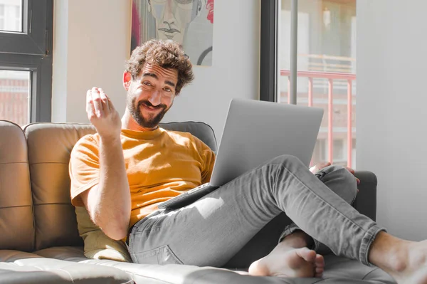 Genç sakallı adam sana borcunu ödemeni söyleyerek kapiş ya da para hareketi yapıyor! Dizüstü bilgisayarlı kanepe konsepti.