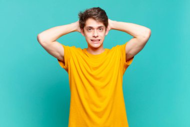 Genç çocuk kendini stresli, endişeli, endişeli ya da korkmuş hissediyor. Elleri başının üstünde, hatayla panikliyor.