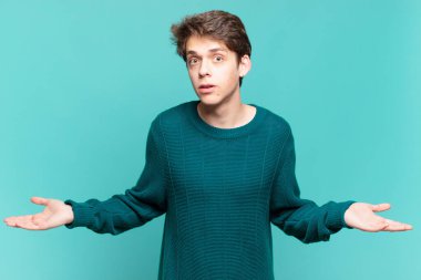 young boy feeling clueless and confused, having no idea, absolutely puzzled with a dumb or foolish look