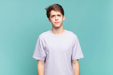 Genç bir çocuk kafası karışık ve kuşkulu, merak ediyor ya da karar vermeye çalışıyor.