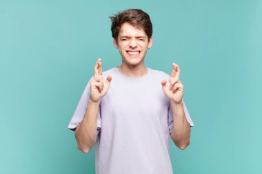 Genç çocuk gergin ve umutlu, şans diliyor ve dua ediyor.