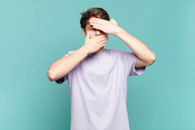 Genç çocuk iki eliyle kameraya hayır diyerek yüzünü kapatıyor! Resimler reddediliyor ya da yasaklanıyor