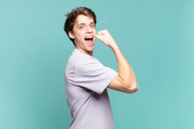 Genç çocuk kendini mutlu, tatmin olmuş ve güçlü hissediyor, kaslı ve formda, spor salonundan sonra güçlü görünüyor.