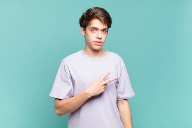 Genç çocuk mutlu, pozitif ve başarılı hissediyor, göğsünde el yapımı V ile, zafer ya da barış gösteriyor.