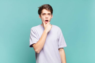 Ağzı ve gözleri açık, eli çenesinde olan genç bir çocuk, nahoş bir şekilde şokta, ne ya da vay canına diyor.