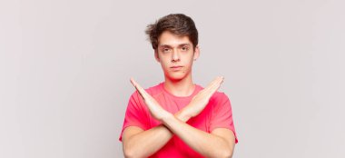 Genç çocuk senin bu tavırlarından rahatsız ve bıkkın görünüyor, yeter artık! Eller önde çapraz, durmanı söylüyor.