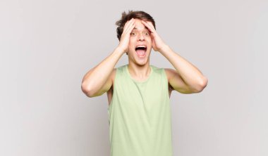 Genç çocuk el ele tutuşuyor, ağzı açık, son derece şanslı, şaşırmış, heyecanlı ve mutlu hissediyor.