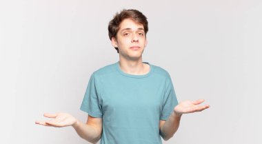 Genç çocuk şaşkın ve kafası karışık, doğru cevap ya da karardan emin değil, bir seçim yapmaya çalışıyor.