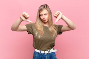 Genç sarışın, güzel bir kadın üzgün, hayal kırıklığına uğramış ya da kızgın görünüyor. Anlaşmazlığa düşmüş, hayal kırıklığına uğramış hissediyor.