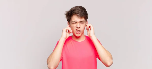 Młody Chłopiec Wygląda Wściekły Zestresowany Zirytowany Zakrywając Uszy Ogłuszającym Hałasem — Zdjęcie stockowe