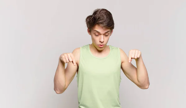 Joven Con Boca Abierta Apuntando Hacia Abajo Con Ambas Manos — Foto de Stock