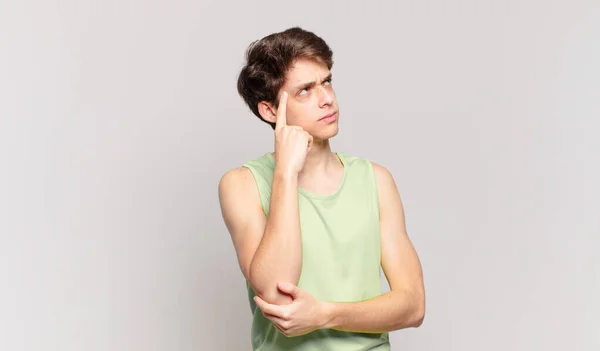 Chico Joven Con Una Mirada Concentrada Preguntándose Con Una Expresión — Foto de Stock