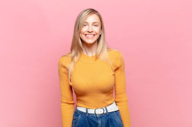 Genç sarışın güzel kadın mutlu ve şapşal görünüyor. Geniş, eğlenceli, deli gülüşü ve gözleri açık.