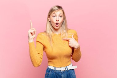 Genç, sarışın, güzel bir kadın gururlu ve şaşırmış hissediyor. Kendine güvenen, kendini bir numara gibi hisseden.