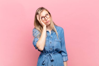 Genç, sarışın, güzel bir kadın yorgun, sıkıcı ve sıkıcı bir işin ardından sıkılmış, hayal kırıklığına uğramış ve uykulu hissediyor.