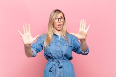 Genç sarışın güzel kadın sersemlemiş ve korkmuş hissediyor. Korkutucu bir şeyden korkuyor. Elleri açık ve uzak dur diyor.