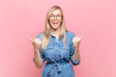 Genç sarışın güzel kadın zaferle bağırıyor, gülüyor, mutlu ve heyecanlı hissediyor başarıyı kutlarken.