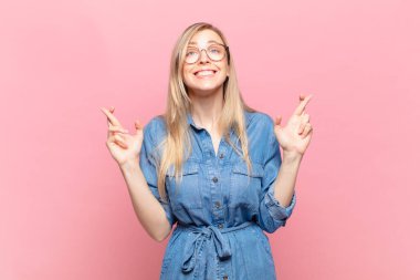 Genç sarışın güzel bir kadın gergin ve umutlu, dua ediyor ve şans diliyor.