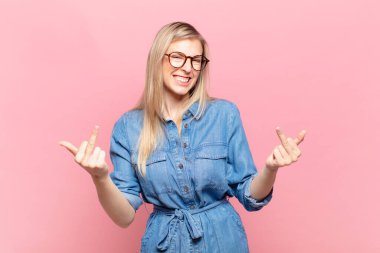 Genç sarışın güzel bir kadın kışkırtıcı, agresif ve müstehcen hissediyor. İsyankar bir tavırla orta parmağını hareket ettiriyor.