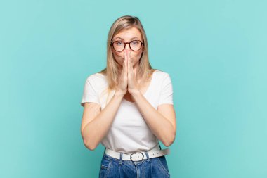 Genç sarışın güzel bir kadın endişeli, umutlu ve dindar hissediyor, sadık bir şekilde avuç içiyle dua ediyor, af diliyor.