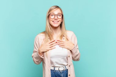 Genç sarışın güzel kadın mutlu, şaşırmış, gururlu ve heyecanlı görünüyor.