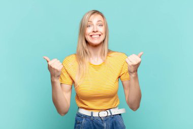 Genç sarışın güzel kadın zaferle bağırıyor, gülüyor, mutlu ve heyecanlı hissediyor başarıyı kutlarken.