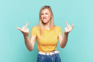 Genç sarışın güzel bir kadın kışkırtıcı, agresif ve müstehcen hissediyor. İsyankar bir tavırla orta parmağını hareket ettiriyor.