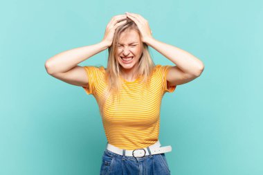 Sarışın, güzel bir kadın stresli ve hayal kırıklığına uğramış hissediyor. Yumruk yumruğa, yorgun, mutsuz ve migren ağrısı çekiyor.