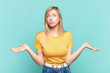 Genç sarışın güzel kadın kafası karışık ve kafası karışık, doğru cevap ya da karardan emin değil, seçim yapmaya çalışıyor.