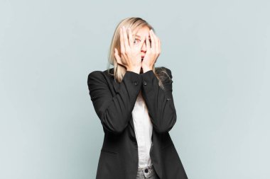 Genç ve güzel iş kadını korkmuş ya da utanmış hisseder. Gözleri yarı kapalı bir şekilde dikizler ya da gözetler.