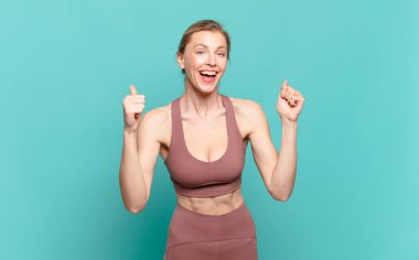 Genç sarışın kadın şok olmuş, heyecanlı ve mutlu hissediyor, gülüyor ve başarıyı kutluyor, vay canına! spor konsepti