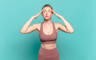 Genç sarışın kadın konsantre, düşünceli ve ilham verici görünüyor, beyin fırtınası yapıyor ve hayal kuruyor. spor konsepti