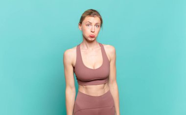 Genç sarışın kadın üzgün ve mızmız, mutsuz bir bakışla, olumsuz ve hayal kırıklığına uğramış bir tavırla ağlıyor. spor konsepti