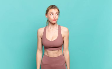 Genç sarışın kadın merak ediyor, mutlu düşünceler ve fikirler düşünüyor, hayal kuruyor, uzayı kopyalamak istiyor. spor konsepti