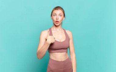 Genç sarışın kadın şaşkın, şaşkın ve güvensiz hissediyor, kendini gösterip kim olduğumu soruyor, ben mi? spor konsepti