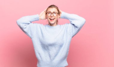 Genç, güzel sarışın kadın stresli, endişeli ya da korkmuş hissediyor. Elleri başının üstünde, hata yaptığında panikliyor.