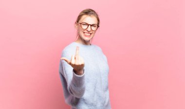 Genç, güzel sarışın kadın kızgın, sinirli, asi ve agresif hissediyor, orta parmağını sallıyor, karşı koyuyor.