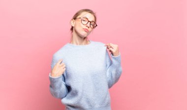 Genç, güzel sarışın kadın kibirli, başarılı, pozitif ve gururlu görünüyor.