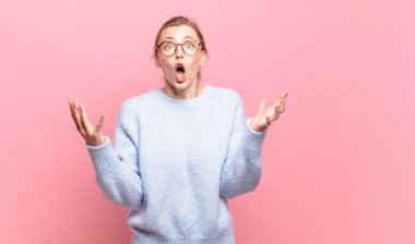 Genç, güzel, sarışın, ağzı açık ve şaşkın, şok olmuş ve hayrete düşmüş bir kadın.