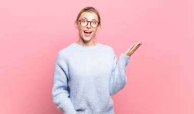 Genç, güzel sarışın kadın mutlu, şaşkın ve neşeli, pozitif bir tavırla gülümseyen, bir çözüm ya da fikir gerçekleştiren.