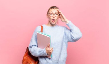 Genç ve güzel bir öğrenci mutlu görünüyor, şaşırmış ve şaşırmış, gülümsüyor ve inanılmaz ve inanılmaz iyi haberleri fark ediyor.