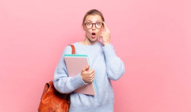 Genç ve güzel bir öğrenci şaşırmış, ağzı açık, şok olmuş, yeni bir düşünce, fikir ya da konsept keşfediyor.