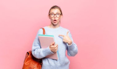 Genç ve güzel bir öğrenci ağzı açık, şaşkın ve şaşırmış bir şekilde kendini işaret ediyor.