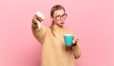 Genç sarışın kadın kızgın, sinirli, hayal kırıklığına uğramış ya da hoşnutsuz hissediyordu. Ciddi bir bakışla reddediyordu. kahve konsepti